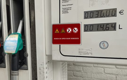 tankstation brandstofpomp waarbij een rood bordje staat met verboden voor vuur en telefoon